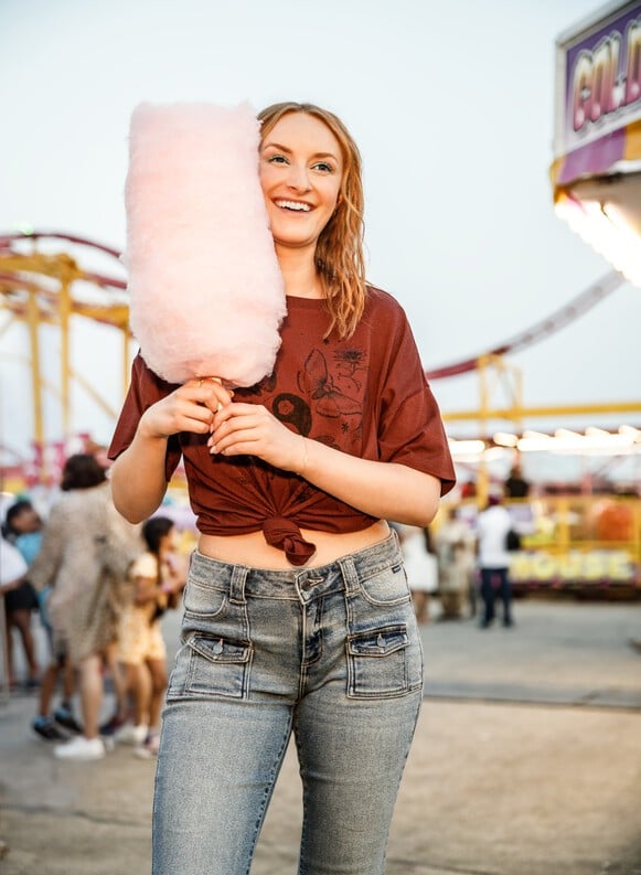 Girl holding cotton candy in cello jeans